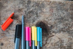 A selection of coloured pens on top of a desk